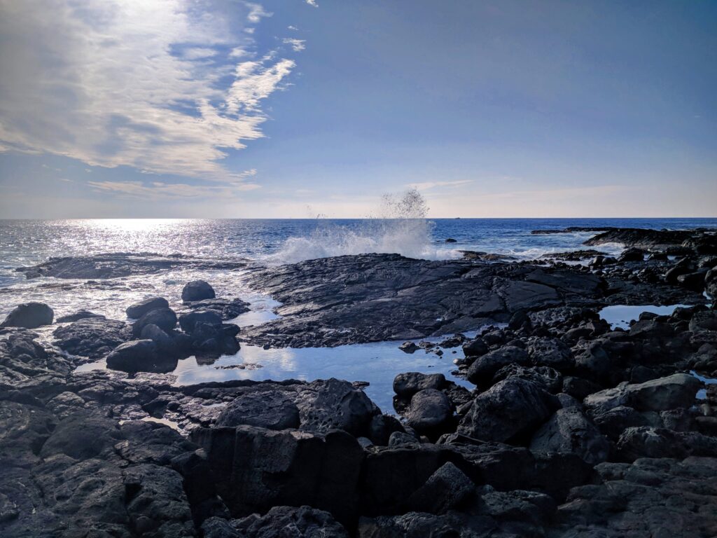 Waves crashing against the lava rocks at Queens Bath.